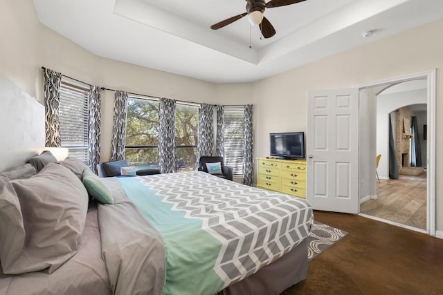 15100 General Williamson Dr, Austin, TX 78734 - bedroom featuring arched walkways, baseboards, a ceiling fan, and a tray ceiling