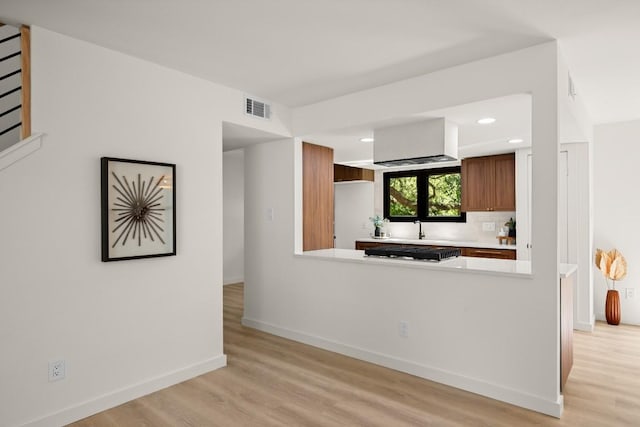 3809 Eton Ln, Austin, TX 78727 - kitchen with light countertops, light wood finished floors, gas cooktop, recessed lighting, and brown cabinets