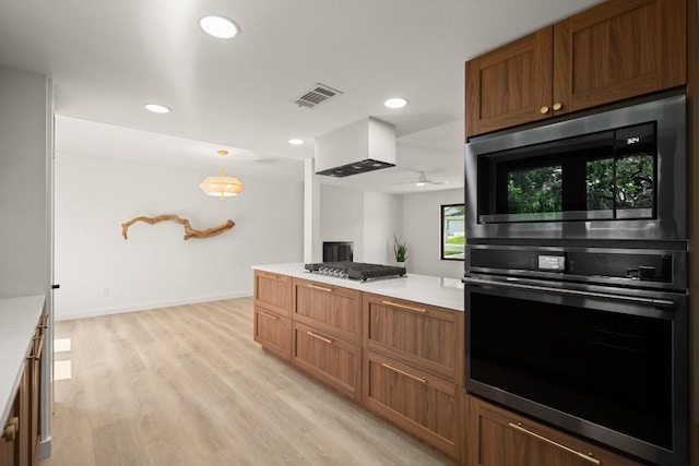 3809 Eton Ln, Austin, TX 78727 - kitchen with built in microwave, light countertops, light wood finished floors, recessed lighting, and brown cabinets