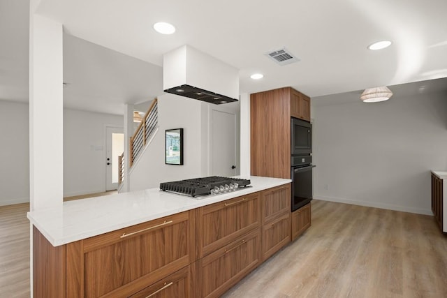 3809 Eton Ln, Austin, TX 78727 - kitchen with black appliances, light wood-style flooring, brown cabinetry, light countertops, and recessed lighting