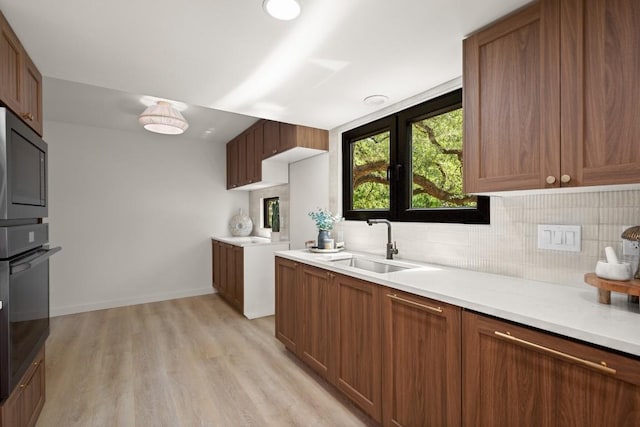 3809 Eton Ln, Austin, TX 78727 - kitchen featuring black appliances, tasteful backsplash, light countertops, light wood-style floors, and brown cabinetry