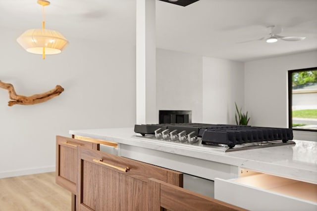 3809 Eton Ln, Austin, TX 78727 - detailed view of wood finished floors, ceiling fan, baseboards, and stainless steel gas stovetop