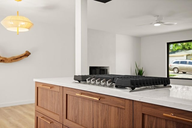 3809 Eton Ln, Austin, TX 78727 - kitchen with light countertops, stainless steel gas cooktop, ceiling fan, light wood finished floors, and open floor plan