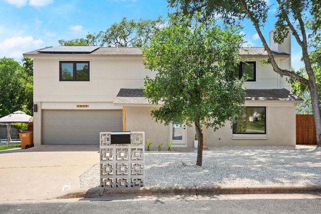 3809 Eton Ln, Austin, TX 78727 - view of front of house with roof mounted solar panels, a shingled roof, concrete driveway, a garage, and stucco siding