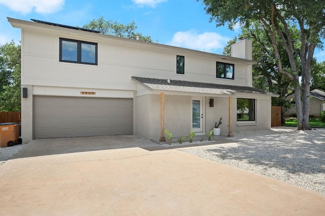 3809 Eton Ln, Austin, TX 78727 - contemporary house with a chimney, an attached garage, concrete driveway, and a shingled roof