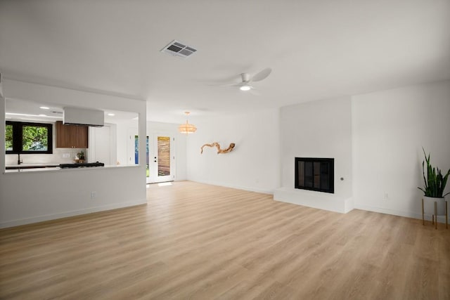 3809 Eton Ln, Austin, TX 78727 - unfurnished living room with light wood-style flooring, ceiling fan, a glass covered fireplace, baseboards, and recessed lighting