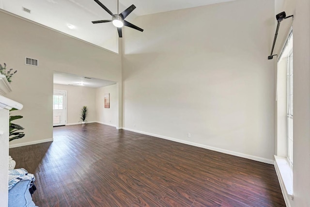 1101 Winecup Ct, Leander, TX 78641 - unfurnished living room with dark wood-style floors, a ceiling fan, baseboards, and a towering ceiling