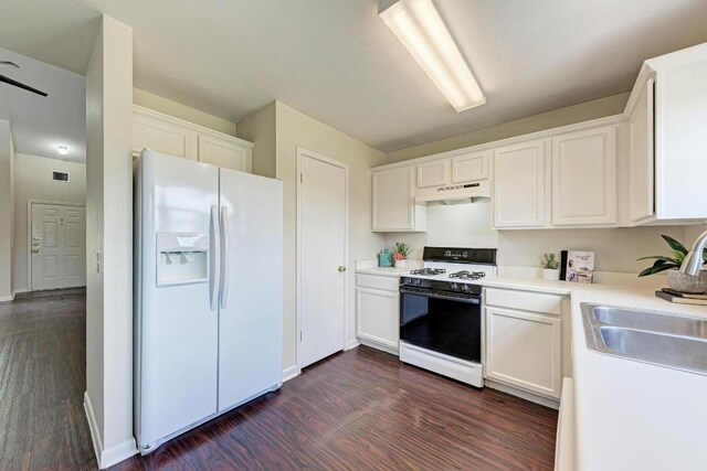 1101 Winecup Ct, Leander, TX 78641 - kitchen featuring white appliances, under cabinet range hood, dark wood finished floors, and white cabinetry