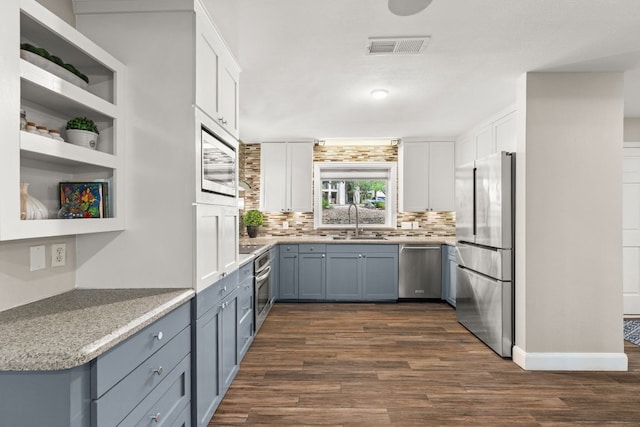 101 Explorer Cv, Lakeway, TX 78734 - kitchen featuring stainless steel appliances, a sink, backsplash, white cabinetry, and dark wood-style flooring