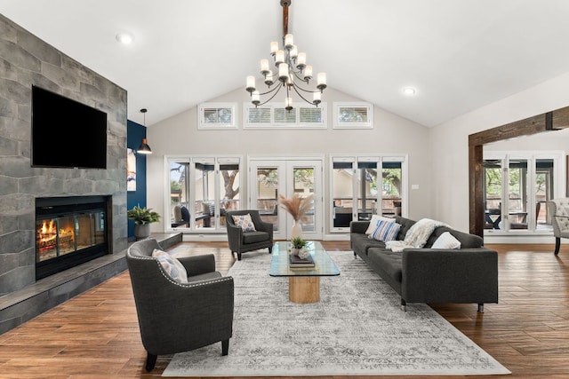 101 Explorer Cv, Lakeway, TX 78734 - living area featuring a chandelier, high vaulted ceiling, a large fireplace, wood finished floors, and french doors