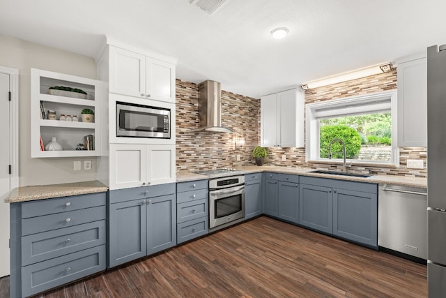 101 Explorer Cv, Lakeway, TX 78734 - kitchen with appliances with stainless steel finishes, a sink, tasteful backsplash, wall chimney range hood, and dark wood finished floors