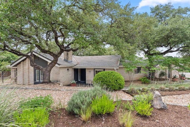 101 Explorer Cv, Lakeway, TX 78734 - rear view of property featuring a chimney, a tiled roof, and brick siding