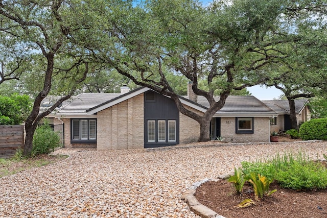 101 Explorer Cv, Lakeway, TX 78734 - view of front of property featuring a tiled roof, a chimney, and brick siding