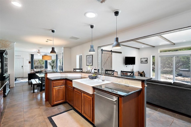 415 Angel Fire Rd, Dripping Springs, TX 78620 - kitchen with open floor plan, dishwasher, a barn door, a sink, and brown cabinetry