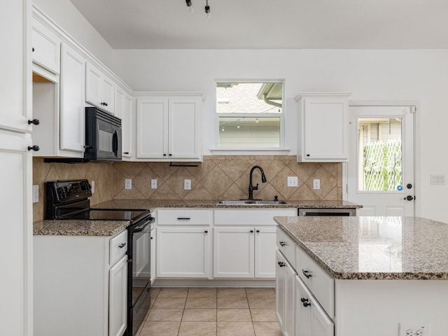 402 Crater Lake Dr, Pflugerville, TX 78660 - kitchen with black appliances, a sink, light stone counters, and tasteful backsplash