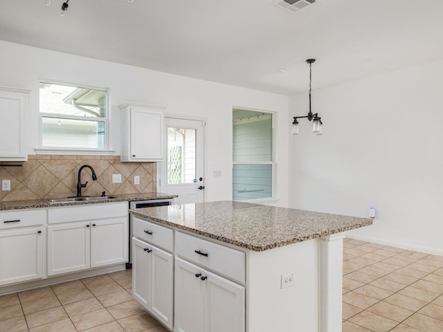 402 Crater Lake Dr, Pflugerville, TX 78660 - kitchen with a sink, light tile patterned flooring, decorative backsplash, and light stone counters