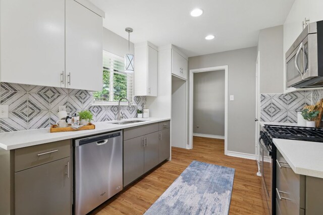 8506 Shenandoah Dr, Austin, TX 78753 - kitchen featuring appliances with stainless steel finishes, a sink, backsplash, light countertops, and white cabinetry