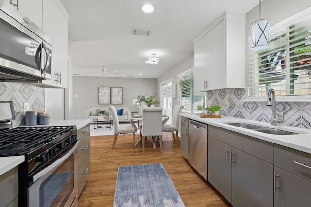 8506 Shenandoah Dr, Austin, TX 78753 - kitchen with appliances with stainless steel finishes, a sink, a ceiling fan, light countertops, and tasteful backsplash