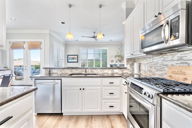 4000 Ranch Road 620 N Unit 7, Austin, TX 78734 - kitchen with stainless steel appliances, a sink, dark stone countertops, white cabinetry, and crown molding