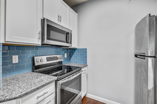2320 Gracy Farms Ln Unit 1024, Austin, TX 78758 - kitchen with appliances with stainless steel finishes, baseboards, tasteful backsplash, and white cabinetry