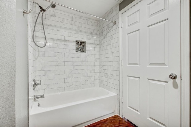 2320 Gracy Farms Ln Unit 1024, Austin, TX 78758 - bathroom featuring tub / shower combination, wood finished floors, and a textured wall