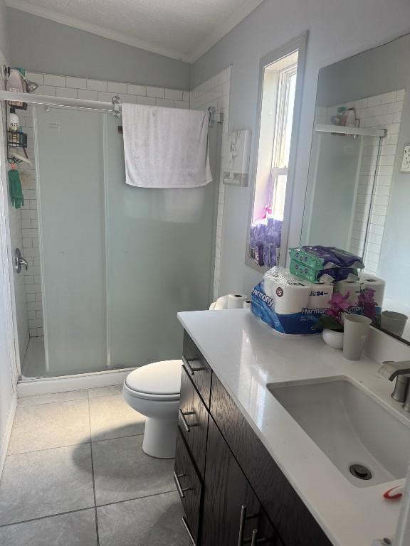 8403 Riverstone Dr, Austin, TX 78724 - full bathroom featuring a shower stall, vanity, toilet, tile patterned flooring, and crown molding
