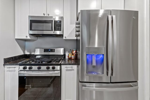 5205 Buffalo Pass, Austin, TX 78745 - kitchen with stainless steel appliances, white cabinets, tile patterned flooring, and dark stone countertops