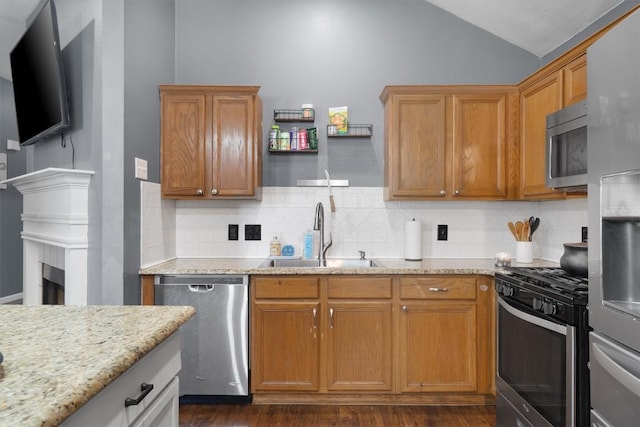 2000 Holly Springs Dr, Taylor, TX 76574 - kitchen featuring stainless steel appliances, backsplash, vaulted ceiling, light stone counters, and dark wood finished floors