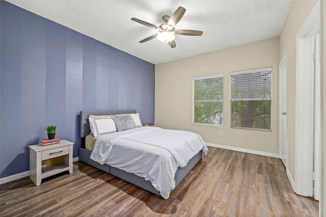 12166 Metric Blvd Bldg 10Unit Unit 246, Austin, TX 78758 - bedroom with wood finished floors, baseboards, a textured ceiling, and a ceiling fan
