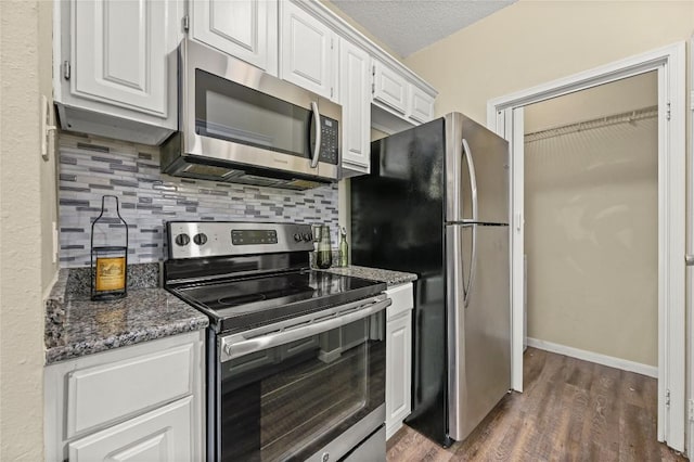 12166 Metric Blvd Bldg 10Unit Unit 246, Austin, TX 78758 - kitchen featuring stainless steel appliances, white cabinetry, decorative backsplash, dark wood finished floors, and dark stone countertops