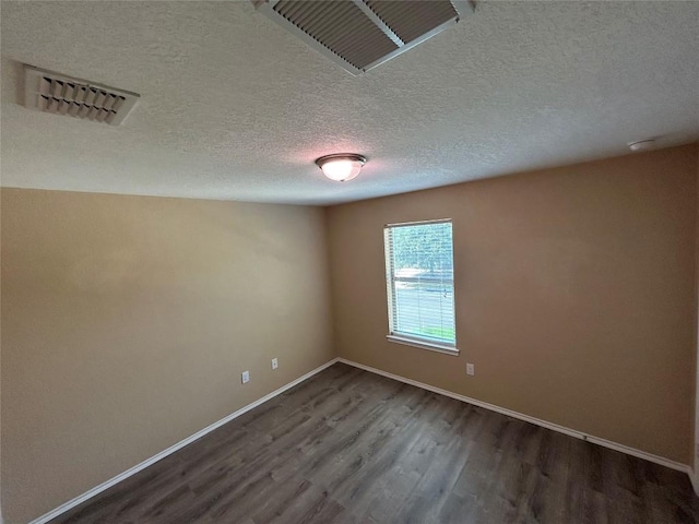 125 Lilly Crk, Boerne, TX 78006 - spare room featuring dark wood-style flooring, baseboards, and a textured ceiling