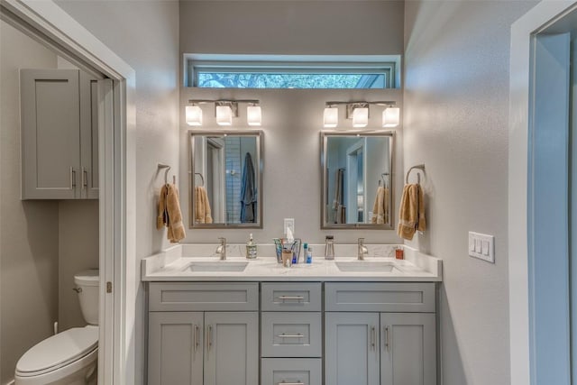 bathroom featuring toilet and double vanity