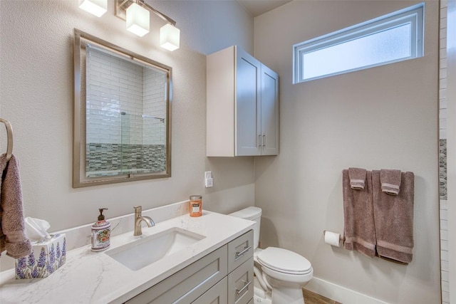 bathroom featuring vanity, toilet, and a shower