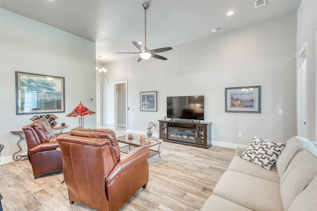 living room featuring light wood finished floors, ceiling fan, baseboards, a towering ceiling, and recessed lighting