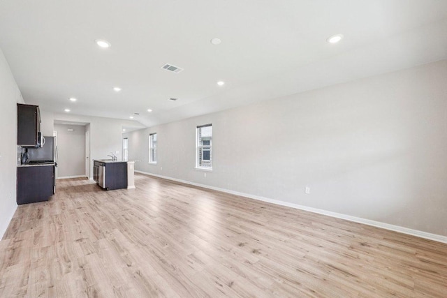 136 Ellinger Rd, Georgetown, TX 78626 - unfurnished living room with light wood-type flooring, baseboards, recessed lighting, and a sink