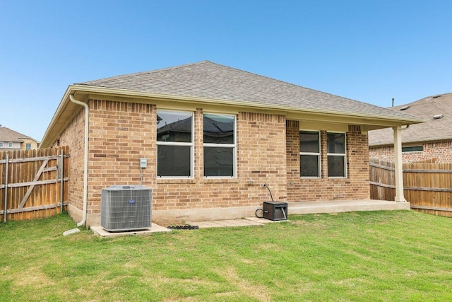 136 Ellinger Rd, Georgetown, TX 78626 - back of property featuring central air condition unit, brick siding, roof with shingles, and a patio area