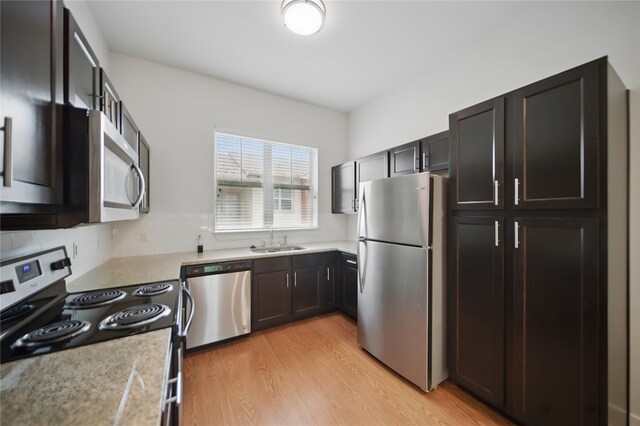 2400 Louis Henna Blvd Unit 106, Round Rock, TX 78664 - kitchen with stainless steel appliances, light countertops, light wood finished floors, and decorative backsplash