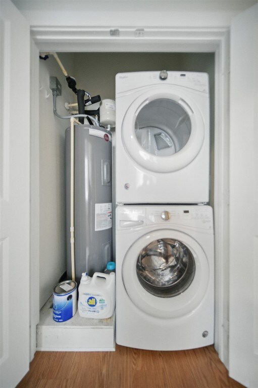 2400 Louis Henna Blvd Unit 106, Round Rock, TX 78664 - laundry area featuring estacked washer and dryer, water heater, and wood finished floors