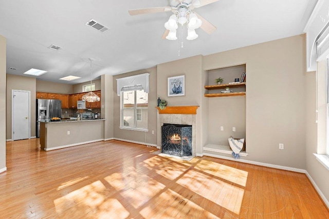 206 Whispering Wind Dr, Georgetown, TX 78633 - unfurnished living room featuring ceiling fan, light wood-style flooring, and a fireplace