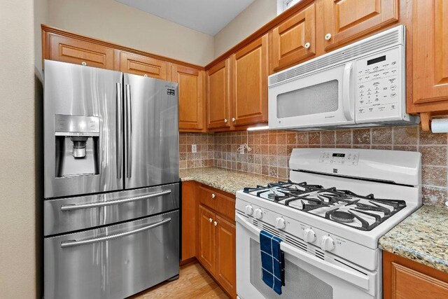 206 Whispering Wind Dr, Georgetown, TX 78633 - kitchen with white appliances, backsplash, and brown cabinets