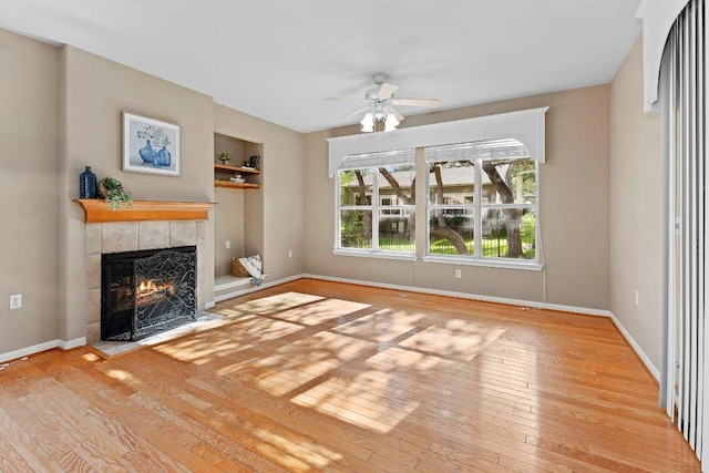 206 Whispering Wind Dr, Georgetown, TX 78633 - unfurnished living room with a tile fireplace, a ceiling fan, and hardwood / wood-style floors