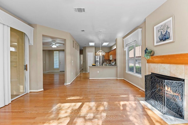 206 Whispering Wind Dr, Georgetown, TX 78633 - unfurnished living room featuring light wood-style floors, a fireplace, and a ceiling fan