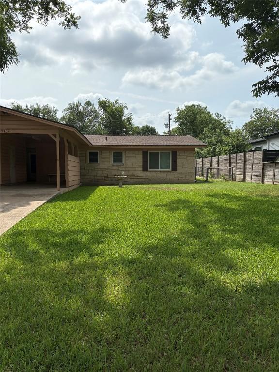 5907 Eureka Dr, Austin, TX 78745 - rear view of property with driveway, stone siding, and a carport