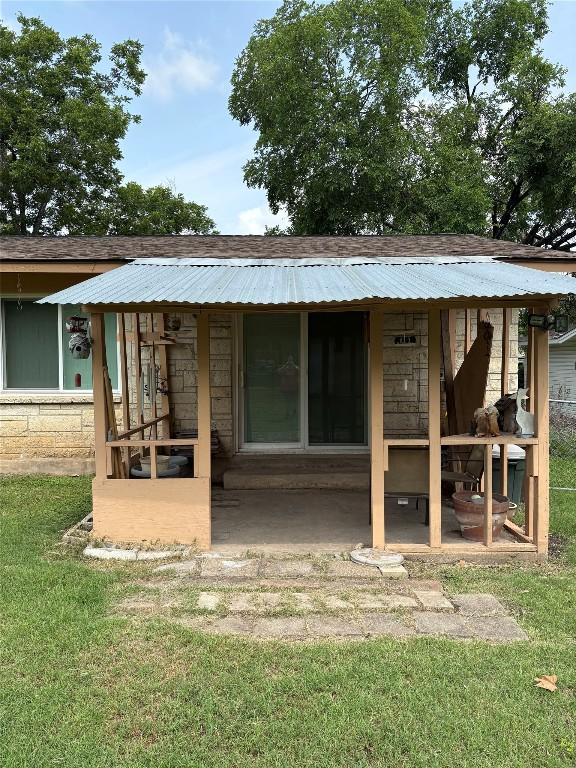 5907 Eureka Dr, Austin, TX 78745 - rear view of property featuring a lawn, stone siding, and a metal roof