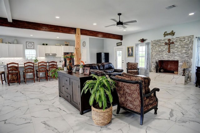 626 Sparta Field Rd, Waelder, TX 78959 - living room featuring beamed ceiling, plenty of natural light, recessed lighting, ceiling fan, and light marble finish flooring