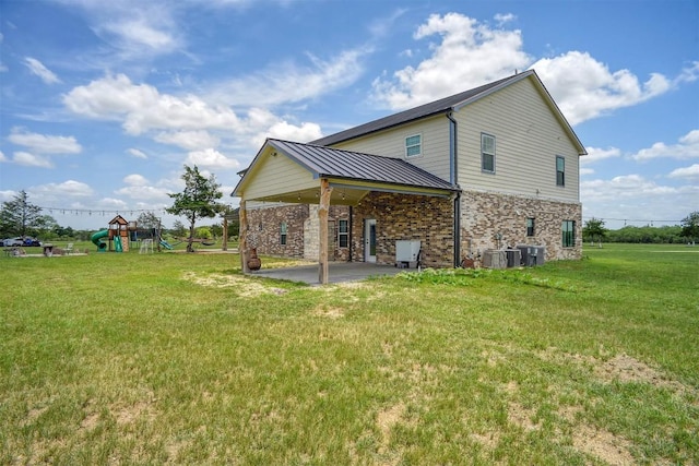 626 Sparta Field Rd, Waelder, TX 78959 - back of property with a patio area, a yard, a playground, a metal roof, and brick siding