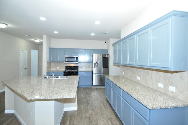 11024 Night Camp Dr, Austin, TX 78754 - kitchen with stainless steel appliances, a sink, backsplash, wood finished floors, and recessed lighting