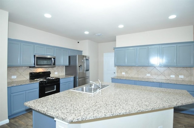11024 Night Camp Dr, Austin, TX 78754 - kitchen featuring appliances with stainless steel finishes, a sink, dark wood-style flooring, a kitchen island with sink, and recessed lighting