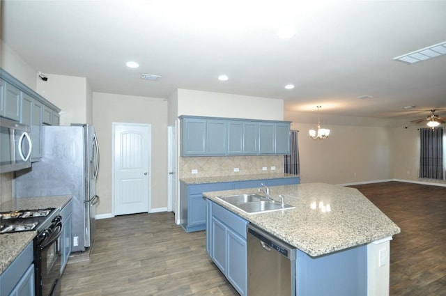 11024 Night Camp Dr, Austin, TX 78754 - kitchen with stainless steel appliances, a sink, open floor plan, an island with sink, and tasteful backsplash