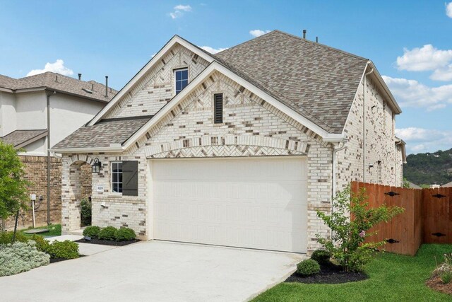8119 Purple Aster Pass, Leander, TX 78645 - french country style house with driveway, a garage, and a shingled roof
